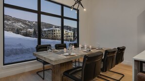 A dining area with a large window overlooking a snowy mountain landscape.