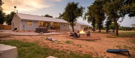 A single-story building with a patio area, outdoor seating, and a fire pit.