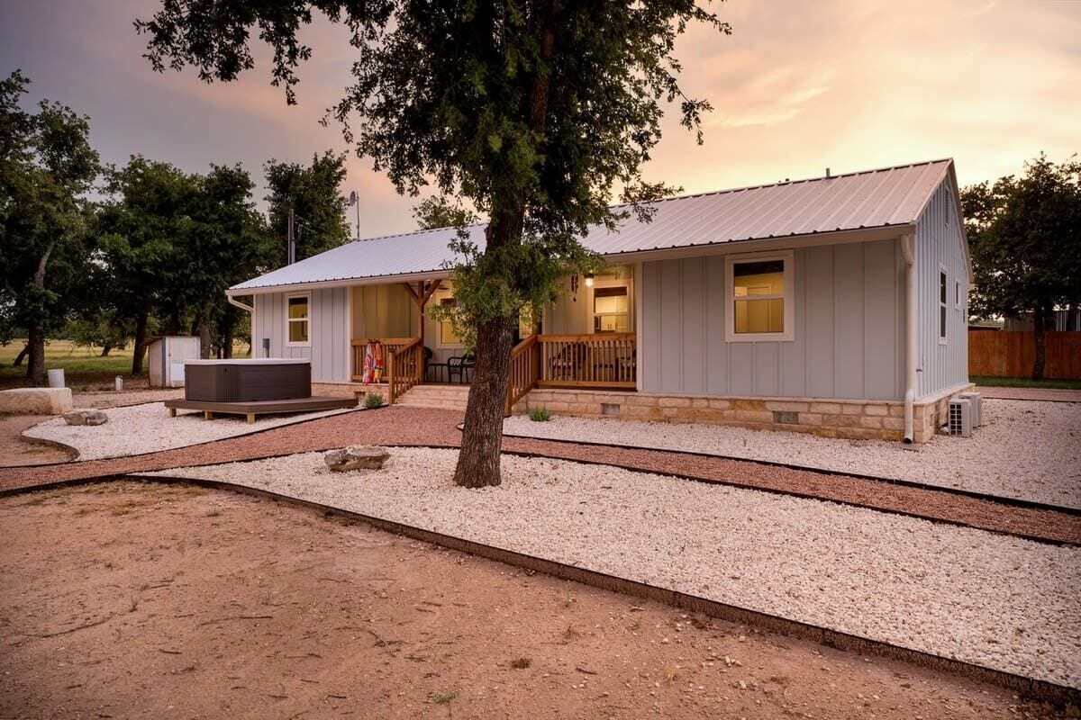 A two-story building with a covered porch and a hot tub.