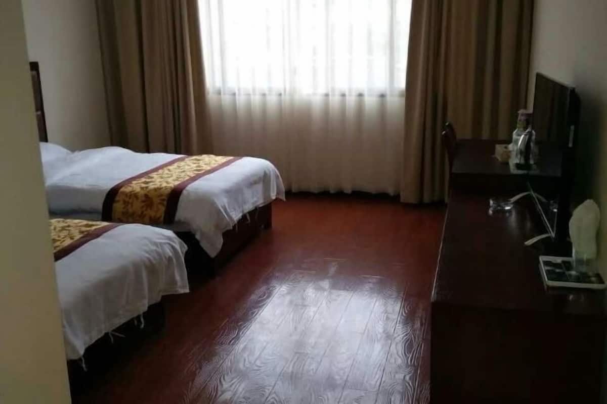 Una habitación de hotel con dos camas, un escritorio y una silla.
