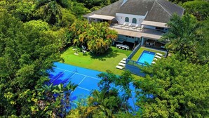A house with a swimming pool surrounded by lush greenery. - Villa Maya: 12 BR, 14k sq. ft. estate with pool, pickle ball, bball, disco club! (Miami)