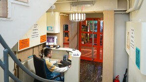 A hotel lobby with a reception desk, a staircase, and a view of the lobby area. - İpek Otel (Balikesir)
