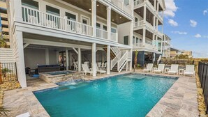 A multi-story building with a swimming pool, outdoor seating, and a covered patio area. - The Beach Club 8BR OF House in Cherry Grove (North Myrtle Beach)
