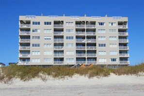 Ein mehrstöckiges Hotel mit Balkonen in Strandnähe.