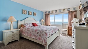 A bedroom with a bed, nightstands, a dresser, and a window with curtains. - Carolina Dunes 502 2BR OF Condo in Cherry Grove (North Myrtle Beach)