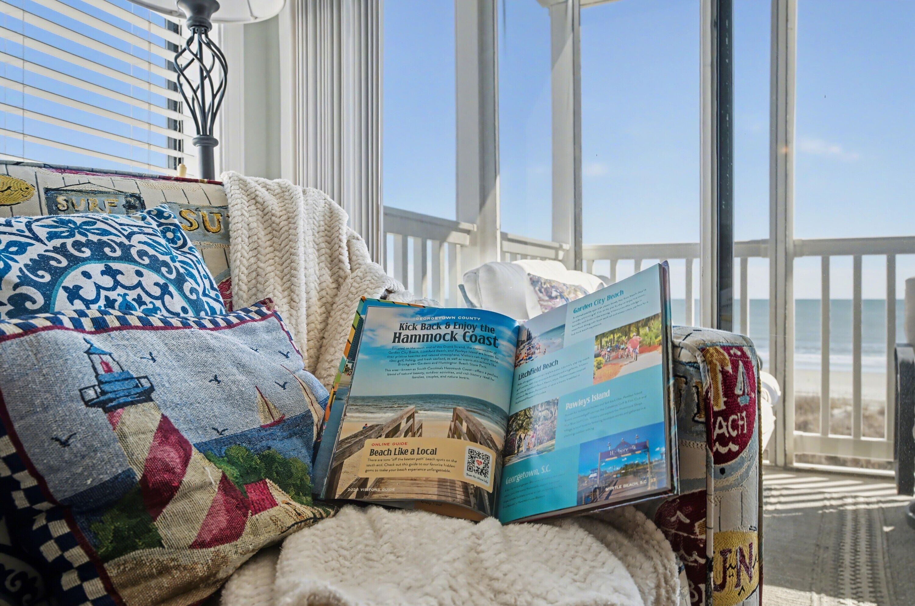 A magazine on a chair with a view of the beach.