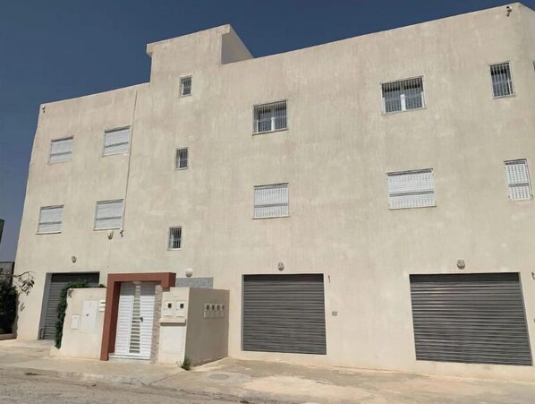 Stylish building with a neutral facade, featuring windows and garage doors.