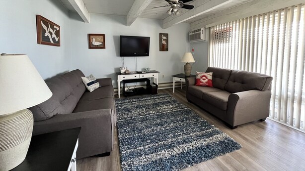 A living room with two sofas, a TV, a ceiling fan, and a window with blinds. - Perfect Getaway. Only 1 block to the Beach (Seaside Park)