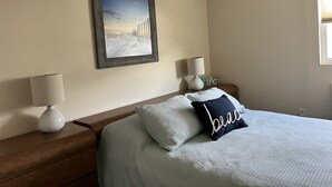 A bedroom with a bed, two bedside tables, a lamp, a framed picture, and a window. - Perfect Getaway. Only 1 block to the Beach (Seaside Park)