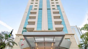 A tall, modern hotel with a central atrium and multiple balconies. - Elegance Suites Oscar Freire (São Paulo)
