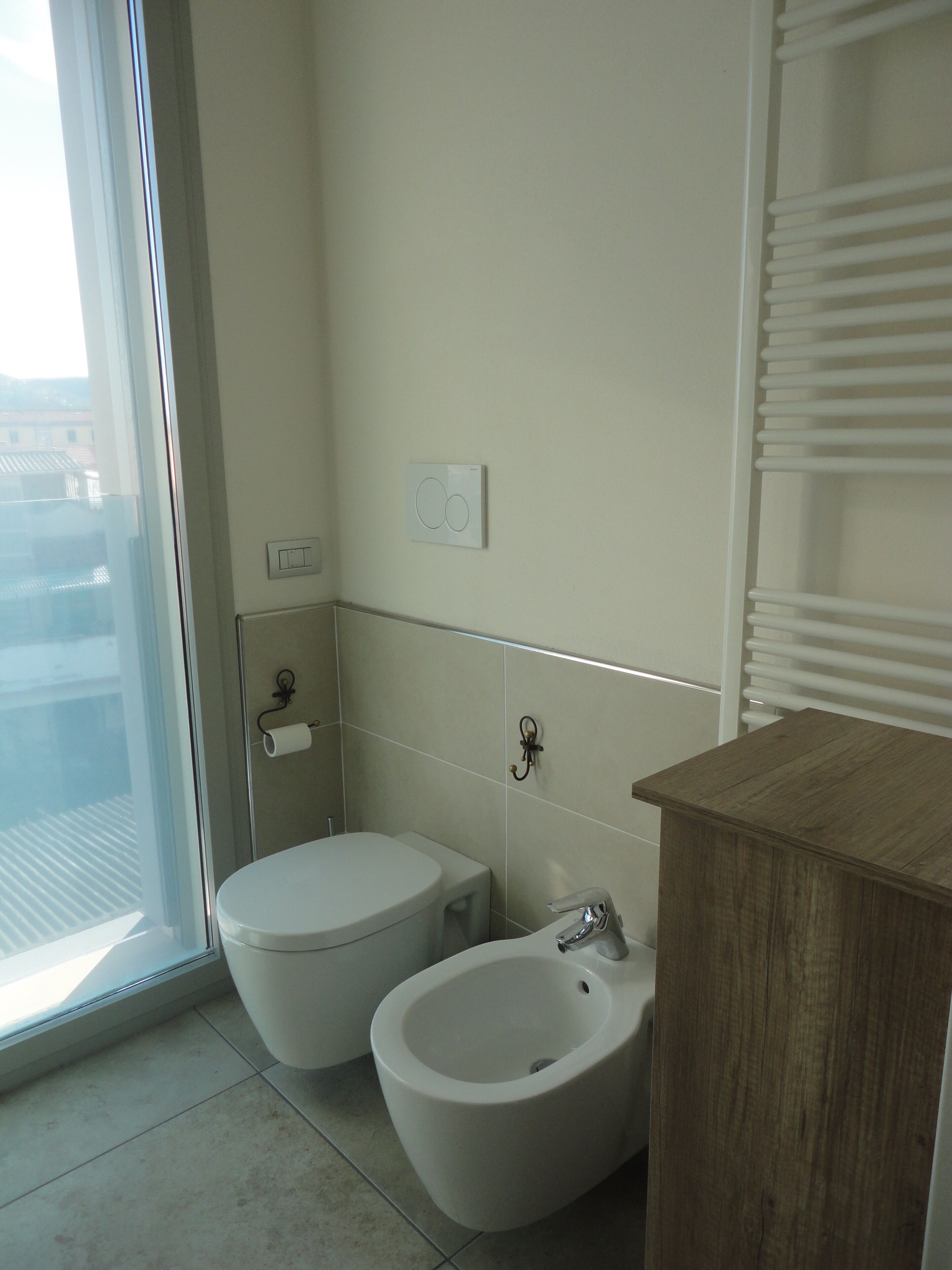 Ein Badezimmer mit Toilette, Bidet und einem Holzausleger.