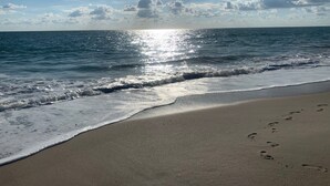 A beach with footprints in the sand, waves, and a clear sky. - Beautiful marina views, manatees and private beach in the Moorings of Vero!  (Vero Beach)