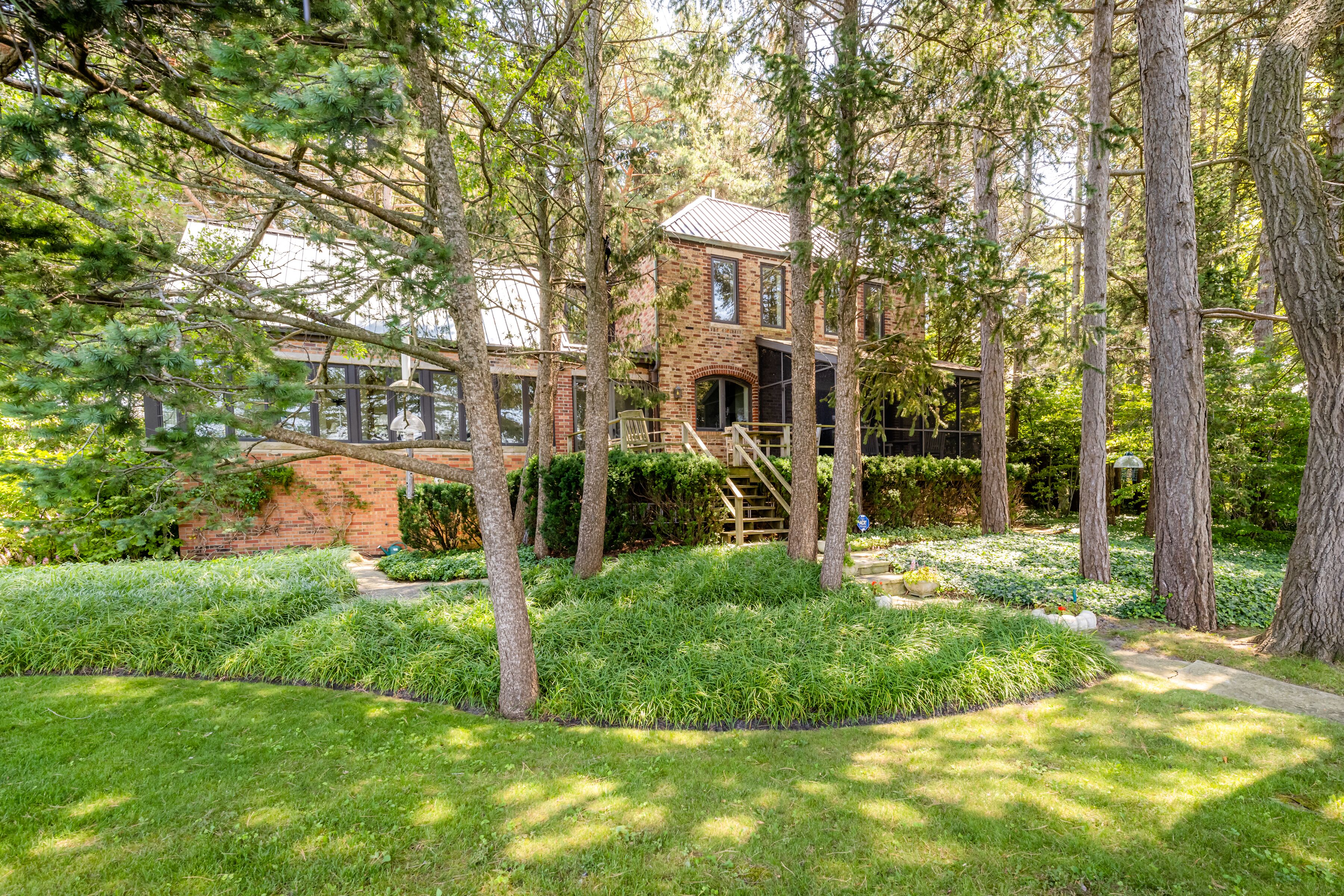 A brick building surrounded by lush greenery and trees.