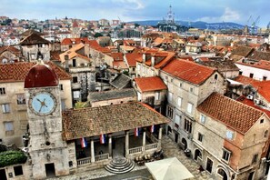 Un paysage urbain d’importance historique, caractérisé par une architecture traditionnelle, notamment une tour de l’horloge imposante et une place centrale agrémentée d’une fontaine.