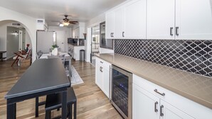 Une cuisine moderne avec des meubles blancs, un plan de travail noir et un pare-feu décoré.