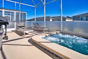 Et tagområde med pool, liggestole og jacuzzi.