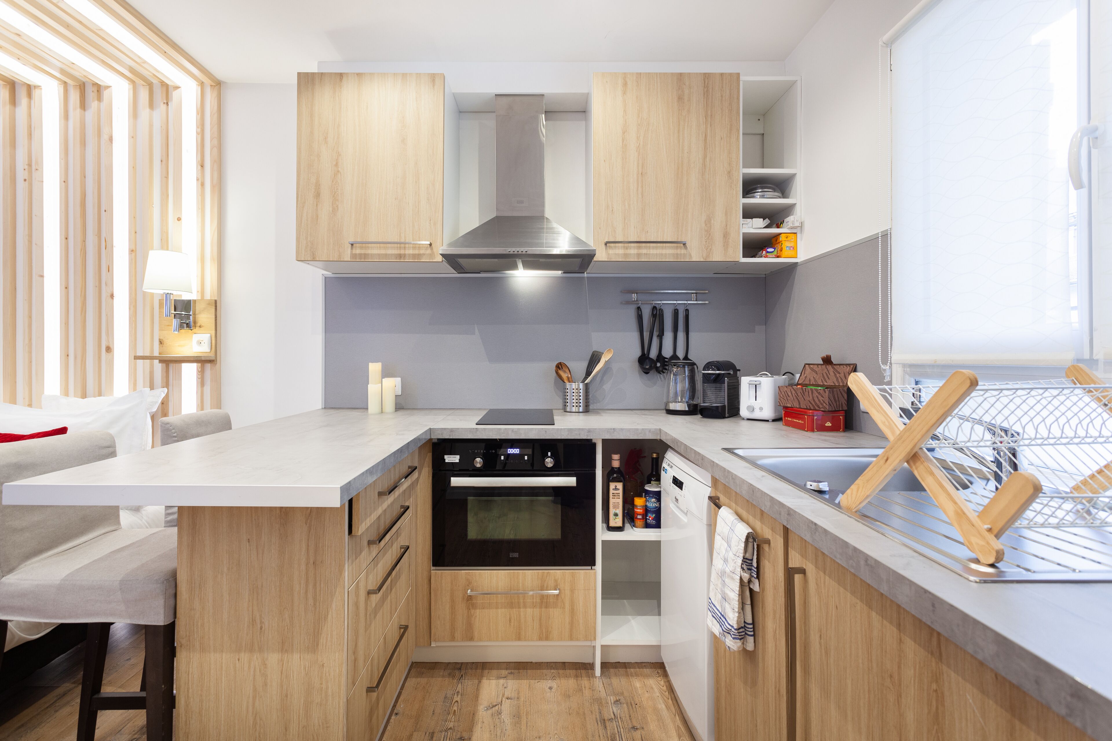A modern kitchen with wooden cabinets, a built-in oven, and a dishwasher.
