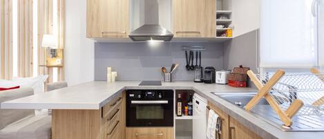 A modern kitchen with wooden cabinets, a built-in oven, and a dishwasher.