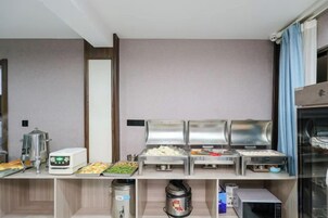 Una mesa de buffet con diferentes alimentos y una máquina de café.