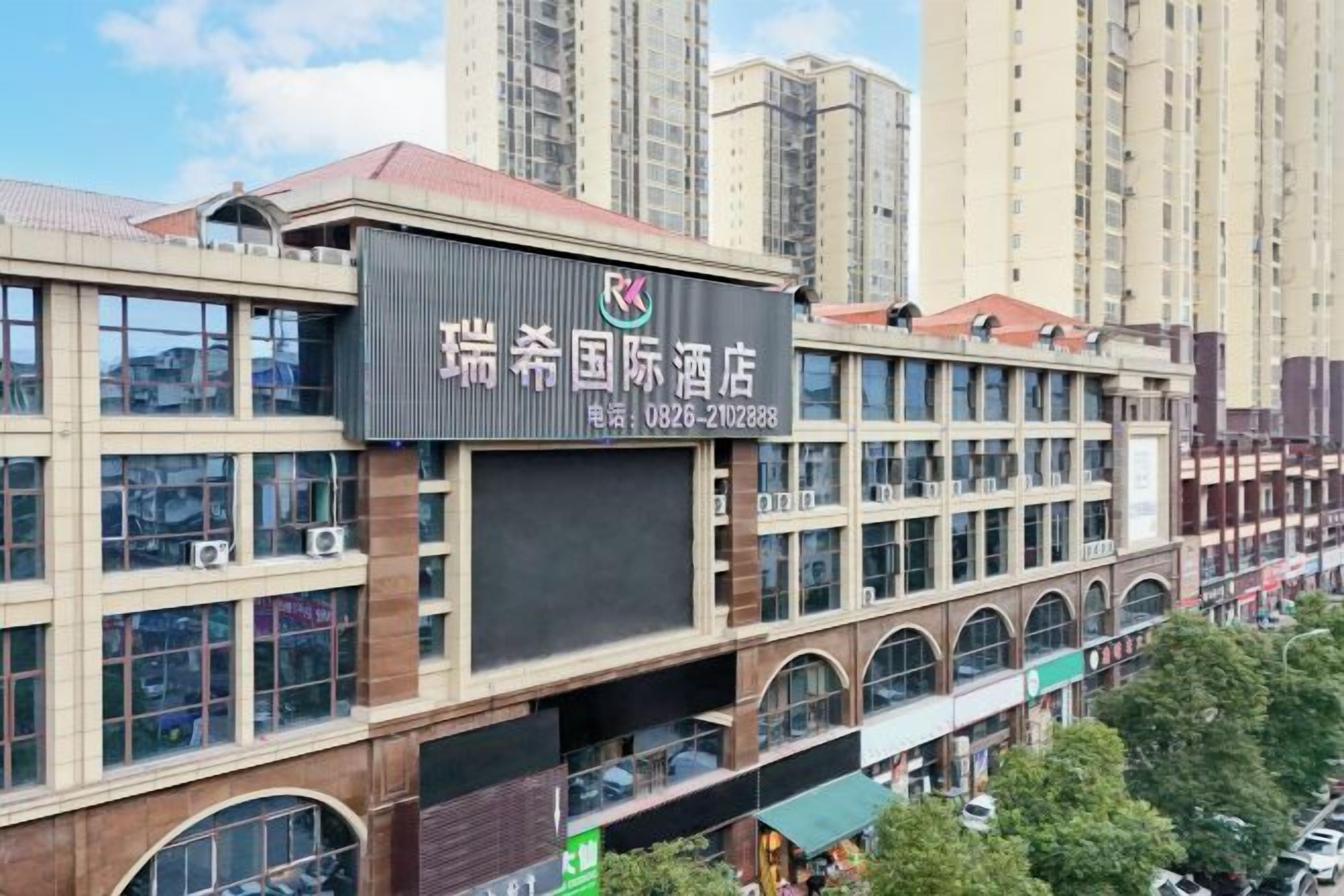 A hotel building with multiple floors, large windows, and a prominent sign.