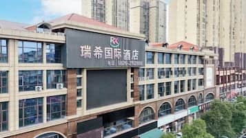 A hotel building with multiple floors, large windows, and a prominent sign.