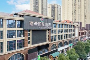 A hotel building with multiple floors, large windows, and a prominent sign. - Ruixi International Hotel (Guang'an Railway Station Branch) (Guang'an)