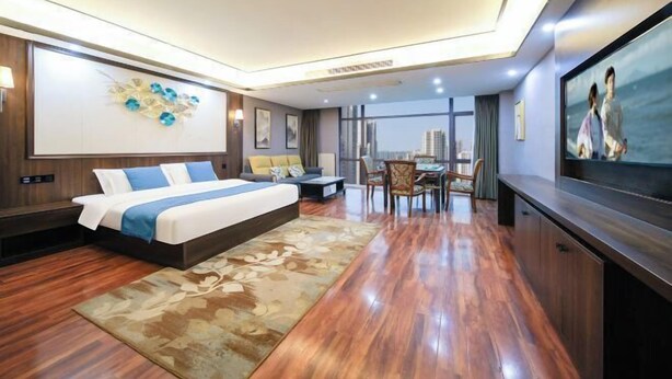 A modern hotel room with a large bed, a dining area, and a city view. - Ruixi International Hotel (Guang'an Railway Station Branch) (Guang'an)