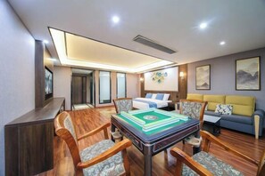 A hotel room with a wooden dining table, chairs, a bed, a sofa, and artwork on the walls. - Ruixi International Hotel (Guang'an Railway Station Branch) (Guang'an)