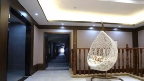 A hallway with a hanging chair, wooden railings, and a ceiling light. - Ruixi International Hotel (Guang'an Railway Station Branch) (Guang'an)