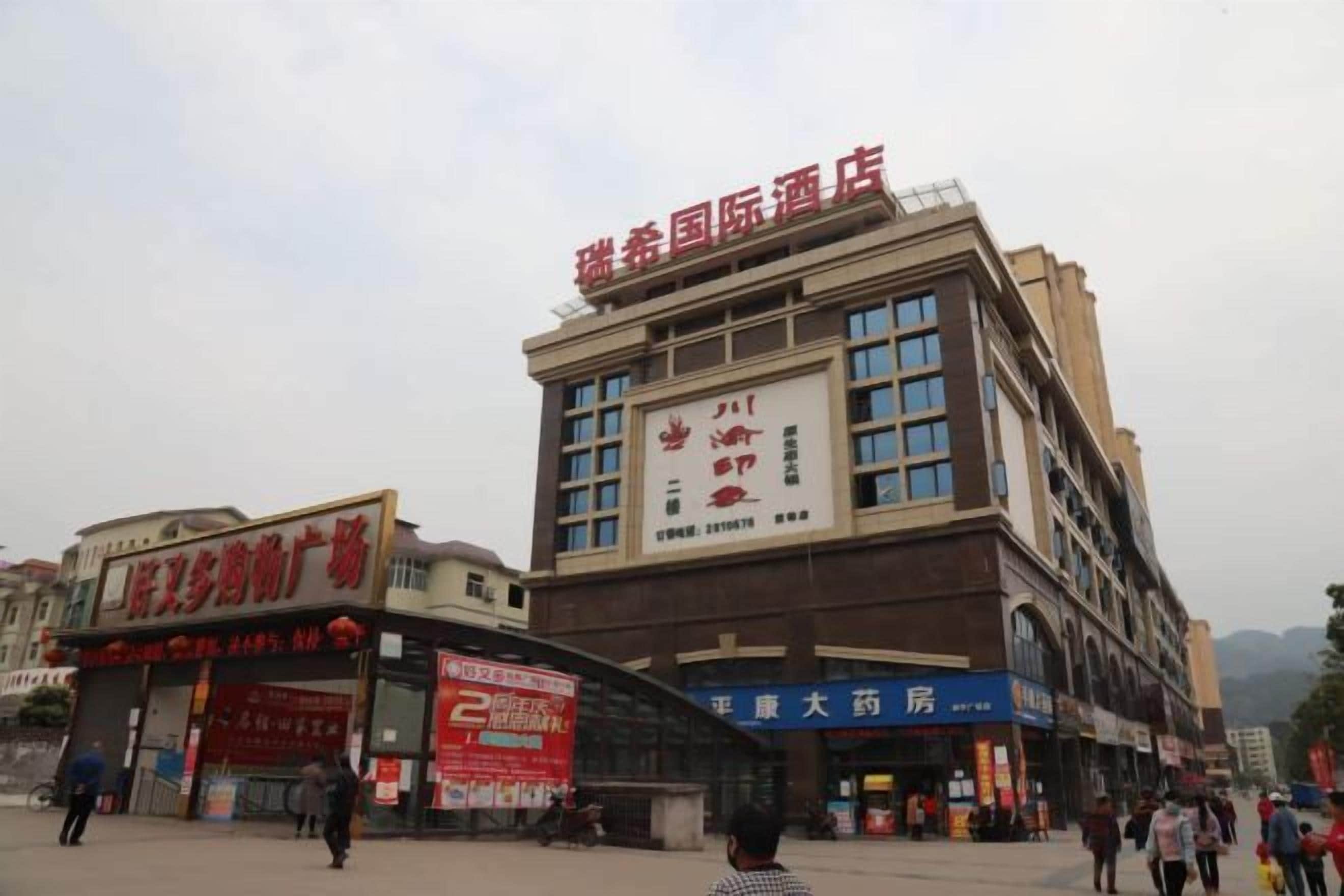 A multi-story building with commercial signage, including a pharmacy and a hotel.