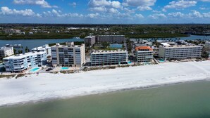 A coastal hotel with multiple buildings, a beach, and a marina.