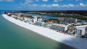 A coastal hotel with multiple buildings, a beach, and a marina.
