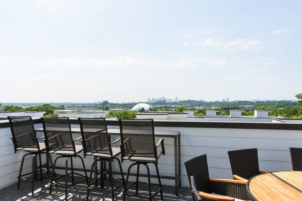 Une terrasse sur le toit, avec des sièges en plein air et une vue sur la ville.