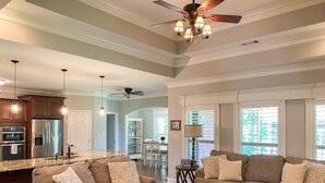 A spacious living room with two sofas, a coffee table, and a ceiling fan. - Beautiful House on the River! Book now for Spring & Summer 2025! (Pangburn)