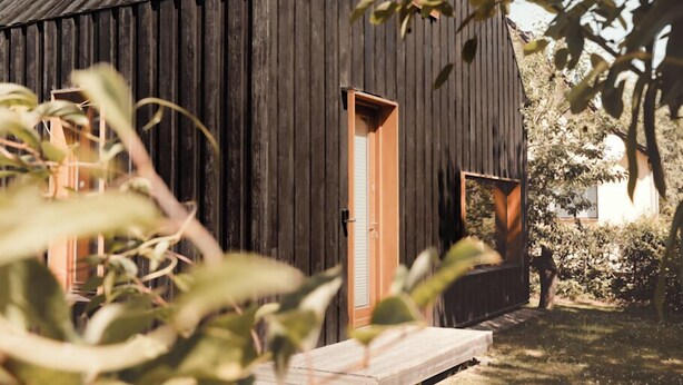 Un edificio rústico de madera con techo inclinado y chimenea.