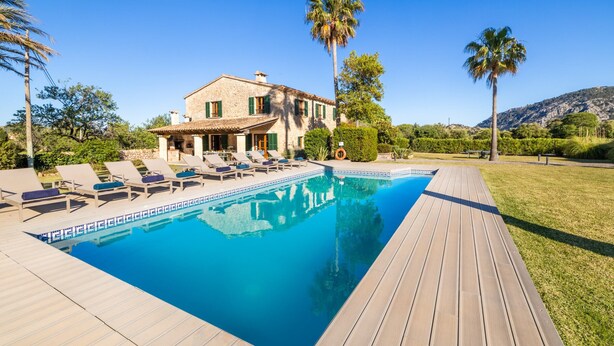 A villa with a swimming pool, lounge chairs, and a wooden deck. - Can Corme (Pollensa)