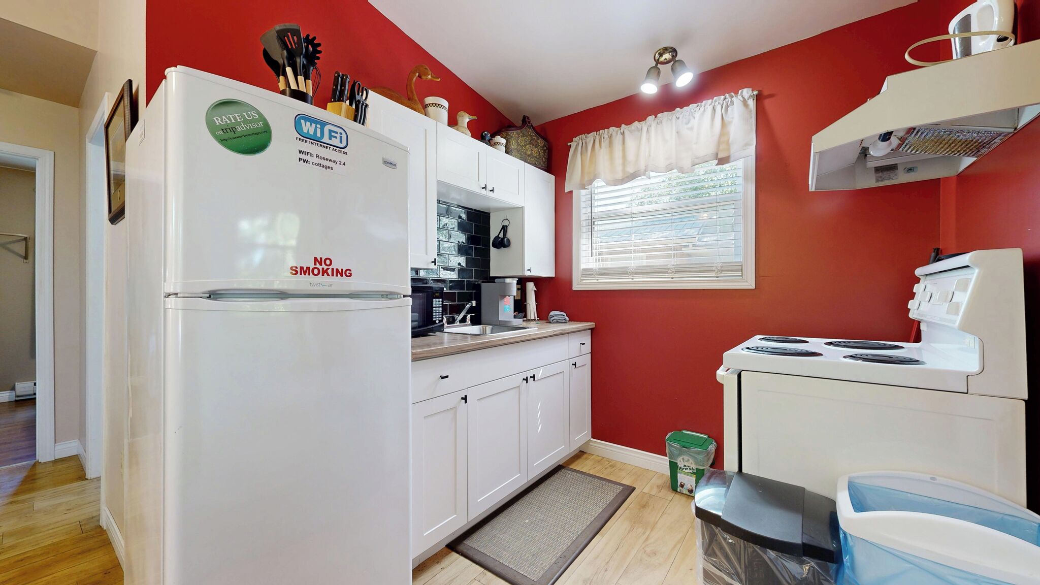 A compact kitchen with a white refrigerator, a stove, and a microwave.
