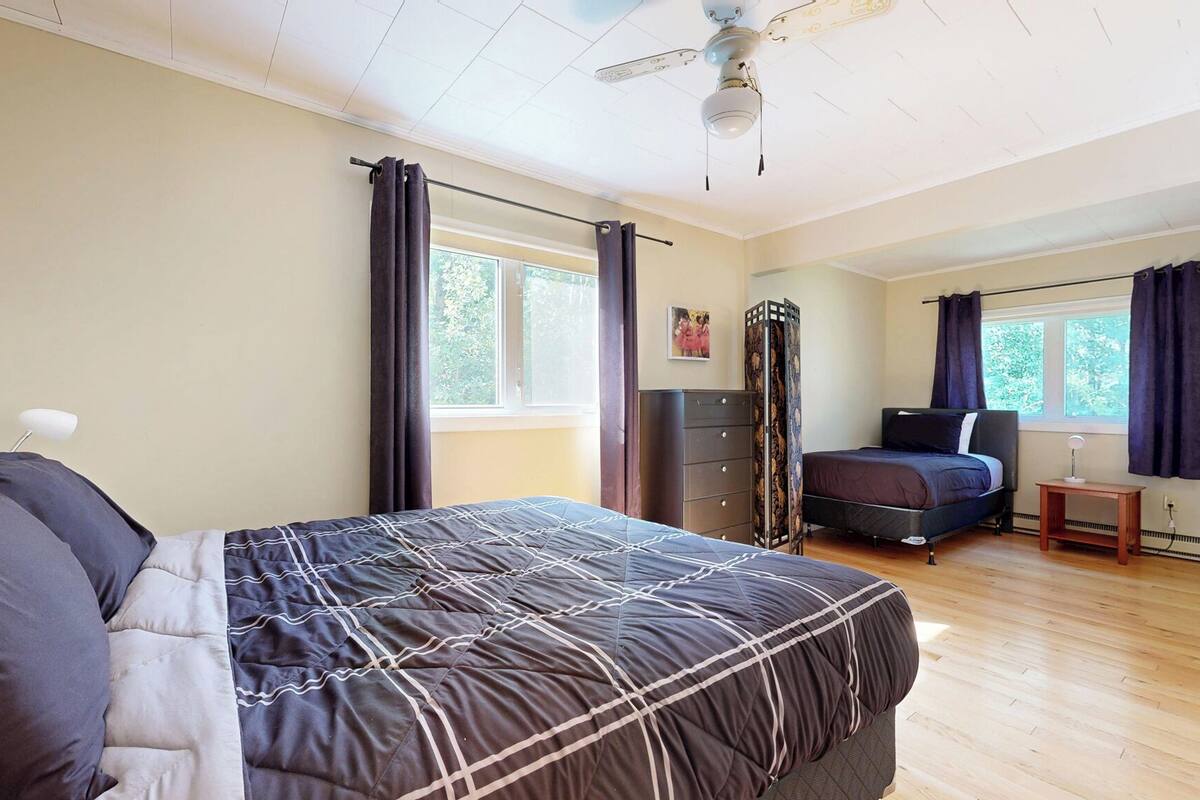 Un dormitorio con cama, cómoda, escritorio y ventana.