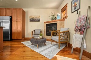 Cozy living area with a modern kitchen, comfortable seating, and a fireplace.