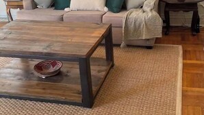 A living room with a wooden coffee table, a beige sofa with green and white cushions, and two side tables with lamps. - PLG Boho Stay (Flatbush) (Brooklyn)