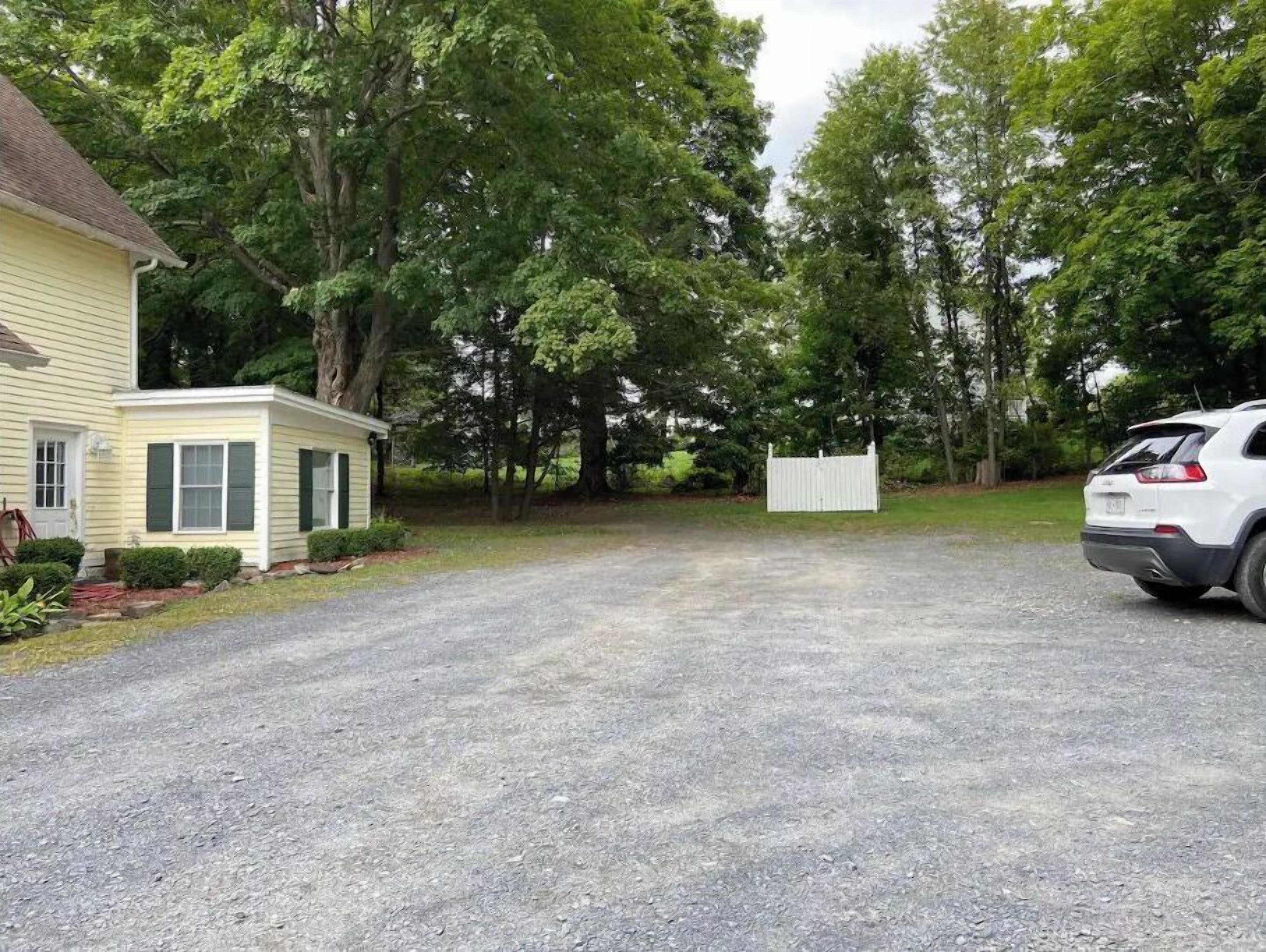 A residential driveway leading to a house with a small attached garage.