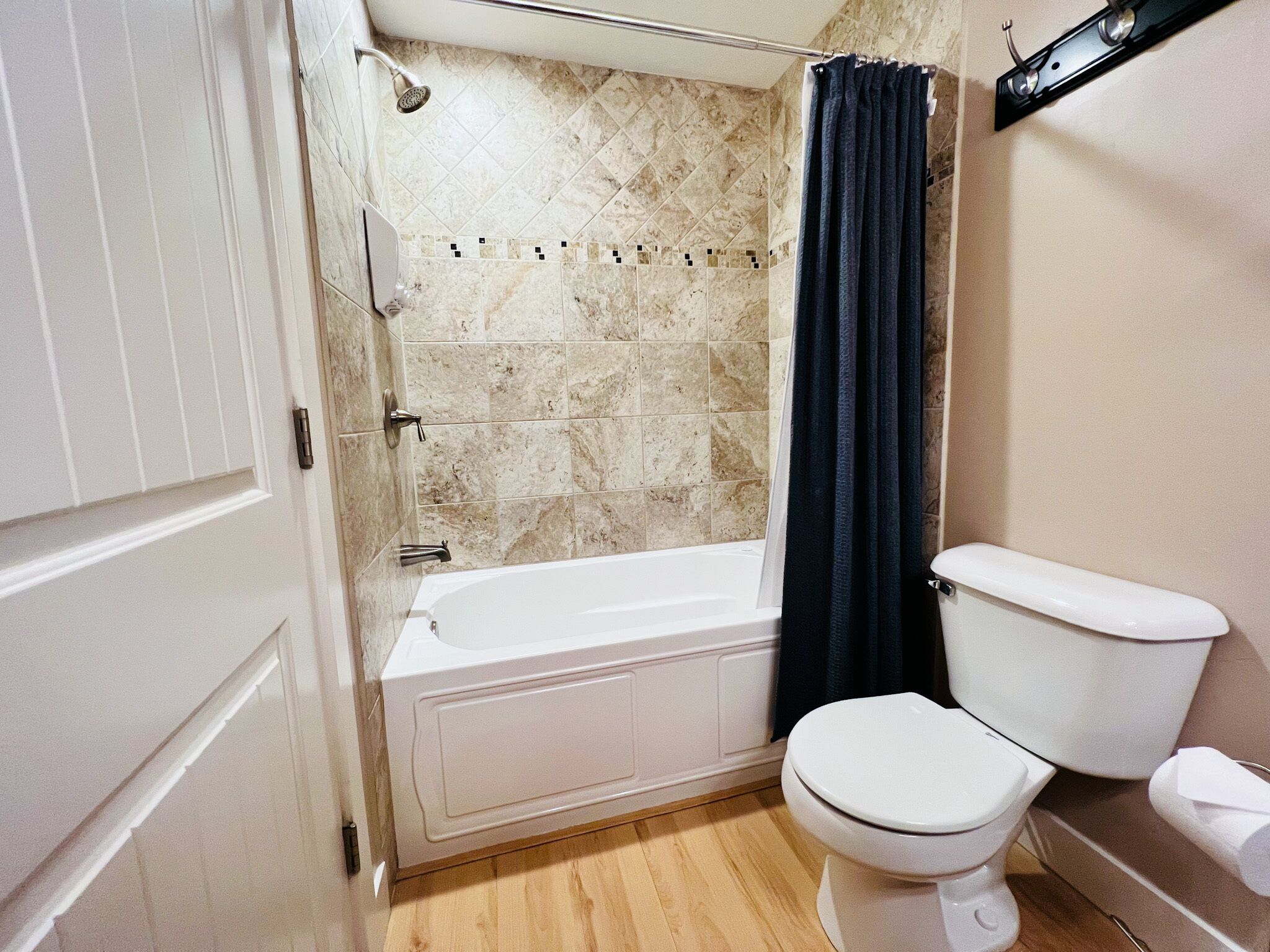 A bathroom with a bathtub, toilet, and shower.