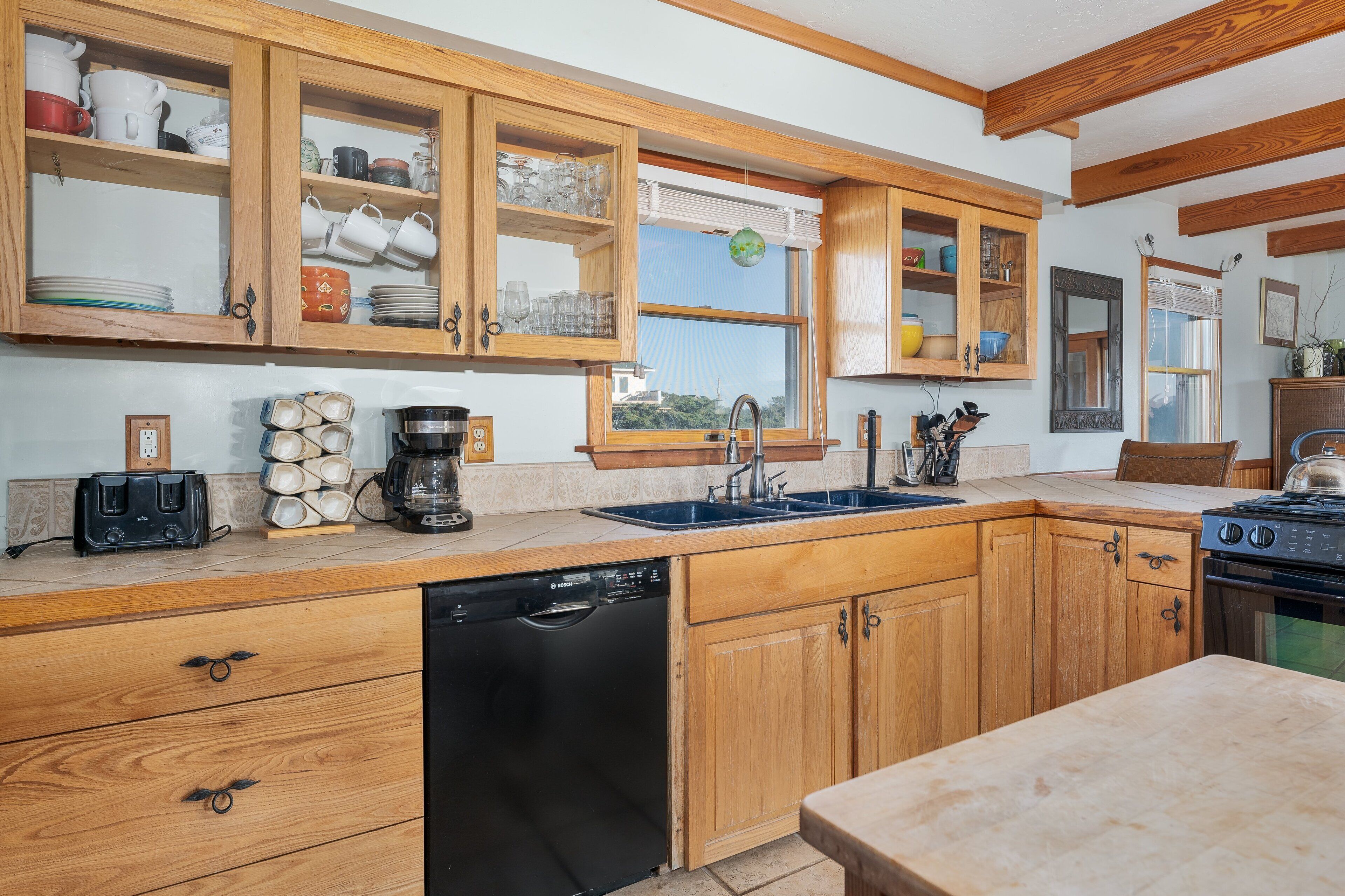 A kitchen with wooden cabinets, a dishwasher, a stove, and a sink.