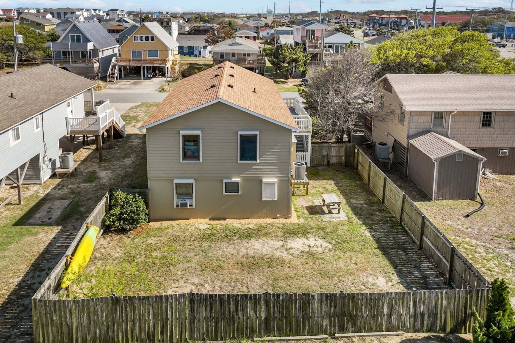 Un quartier résidentiel avec des maisons, une clôture en bois et une petite cour.