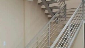 Una escalera con barandillas de metal y peldaños de madera.