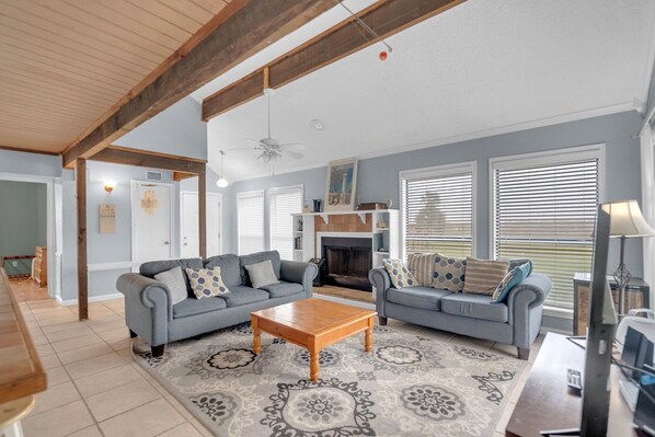 A living room with two sofas, a coffee table, and a fireplace.