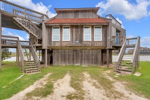A wooden building with multiple levels, a red-tiled roof, and a sign reading 'FOLLY'S COVE.'
