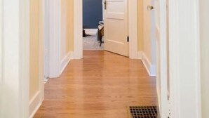 A narrow hallway with wooden flooring and white walls. - The Jackson (Nashville)