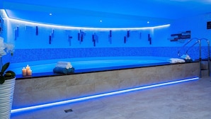 A modern spa area with a curved bench, a sink, and a towel rack. - WX Hotel (Bratislava)