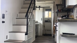 Eine moderne Küche mit weißen Schränken, einer Holz Arbeitsplatte und einem eingebauten Backofen.